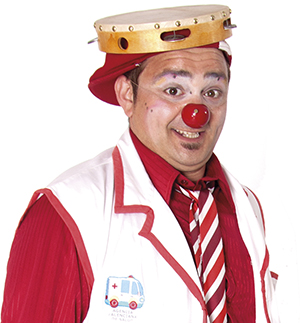 Payaso con camisa roja, bata blanca y roja y pandereta en la cabeza