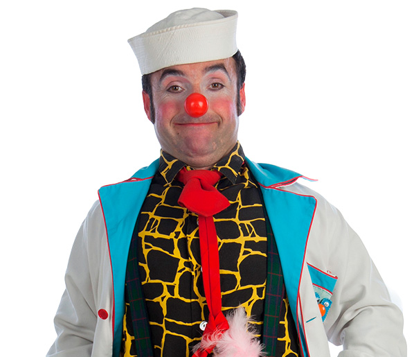 Payaso "Profesor Microscopio" con camisa de estampado amarillo y negro, corbata divertida y bata de Payasospital. Lleva un sombrero de marinero.